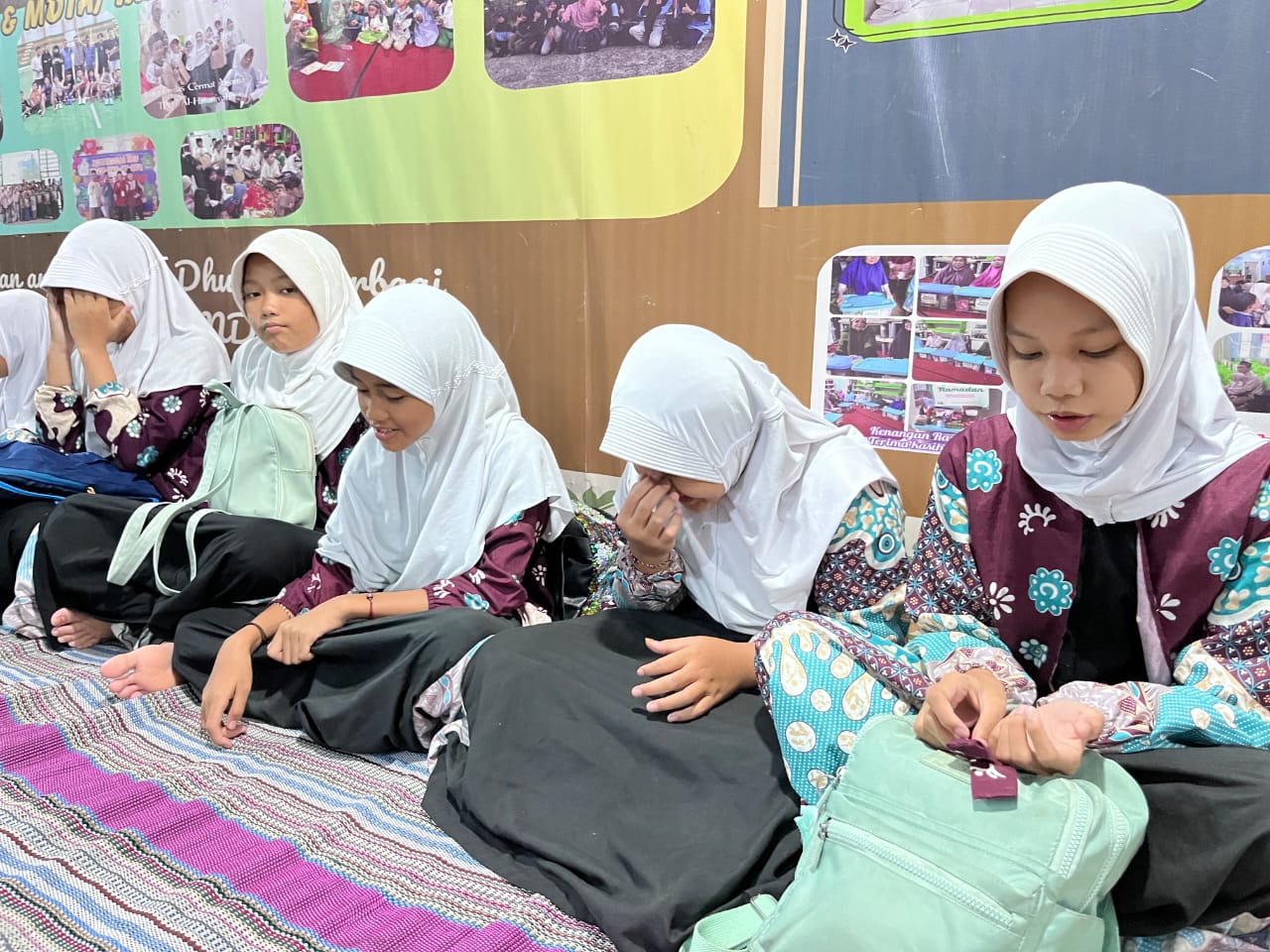 Anak-anak sekolah sedang duduk tenang mendengarkan pemateri oleh Sinergi Puspita